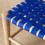 Détail du tressage en damier du cuir bleu sur le bois brut