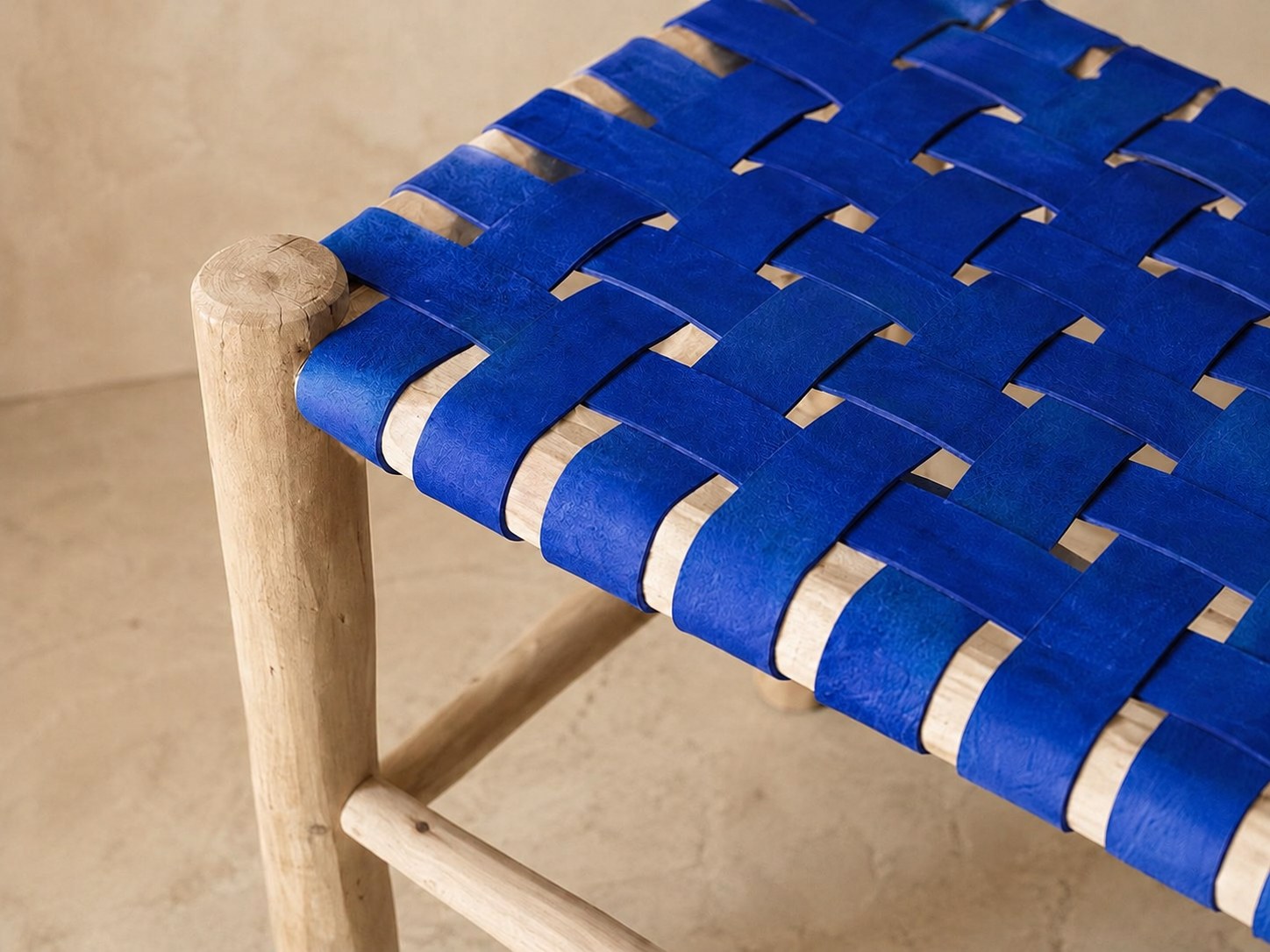 Détail du tressage en damier du cuir bleu sur le bois brut