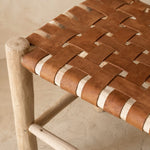 Détail du tressage en damier du cuir cognac sur le bois brut