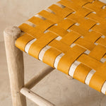 Détail du tressage en damier du cuir jaune sur le bois brut