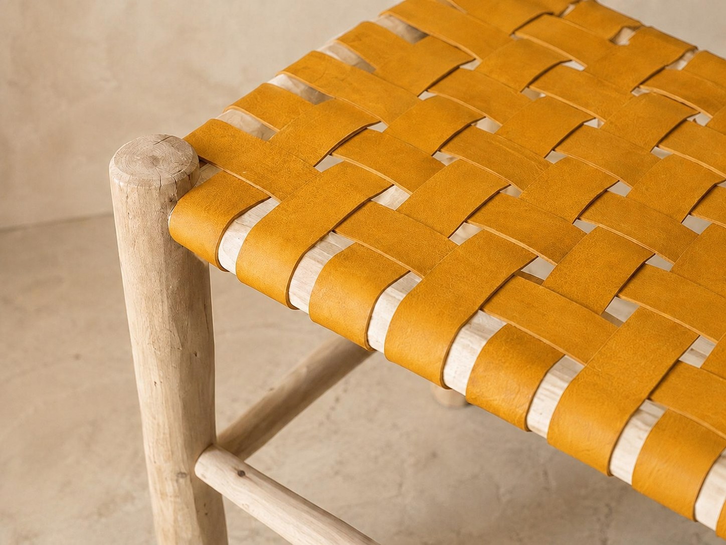 Détail du tressage en damier du cuir jaune sur le bois brut
