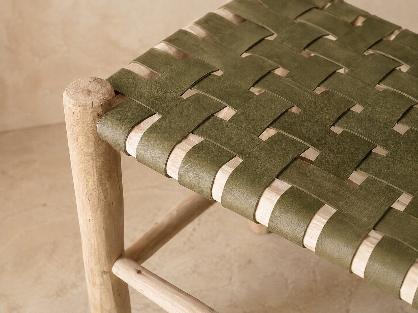 Détail du tressage en damier du cuir kaki sur le bois brut